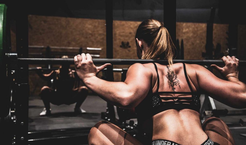 Women lifting barbell in gym