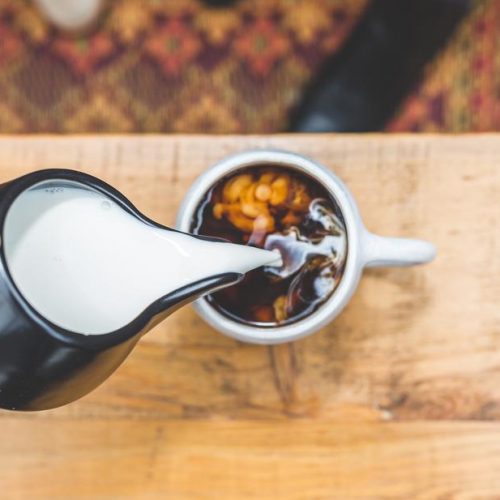 milk being poured to coffee