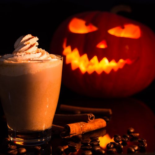 pumpkin spice latte with halloween pumpkin behind
