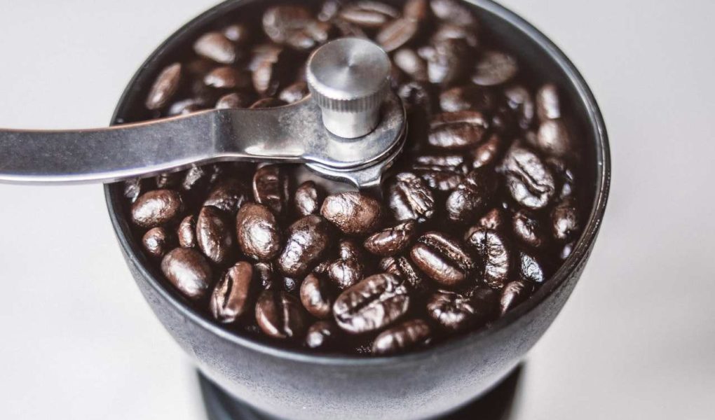 grinding coffee beans with manual coffee grinder